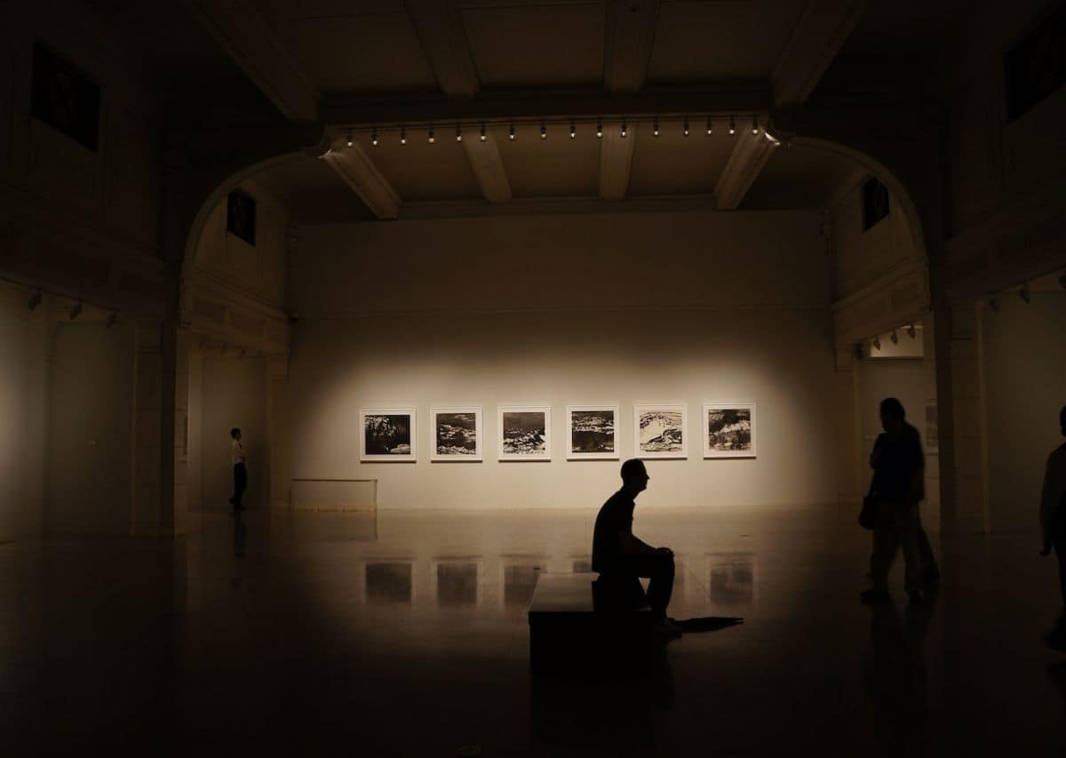 A man staring at the artefact in an empty, dark museum