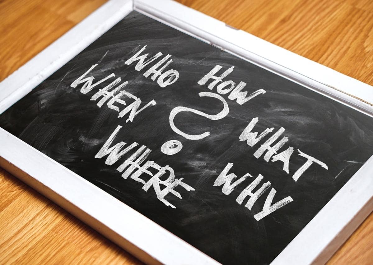 A black board with chalk written "Why""Who""When""What""Where"and "How" as indicators of user intent in crafting keyword research strategy