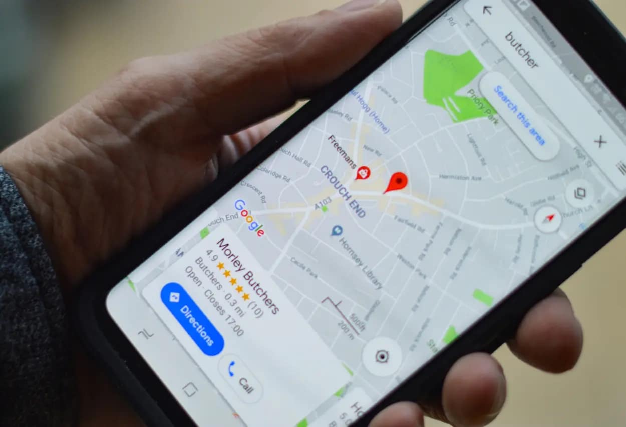 Hand holding a phone with a local map application, emphasizing the impact of local SEO for small business location-based marketing.
