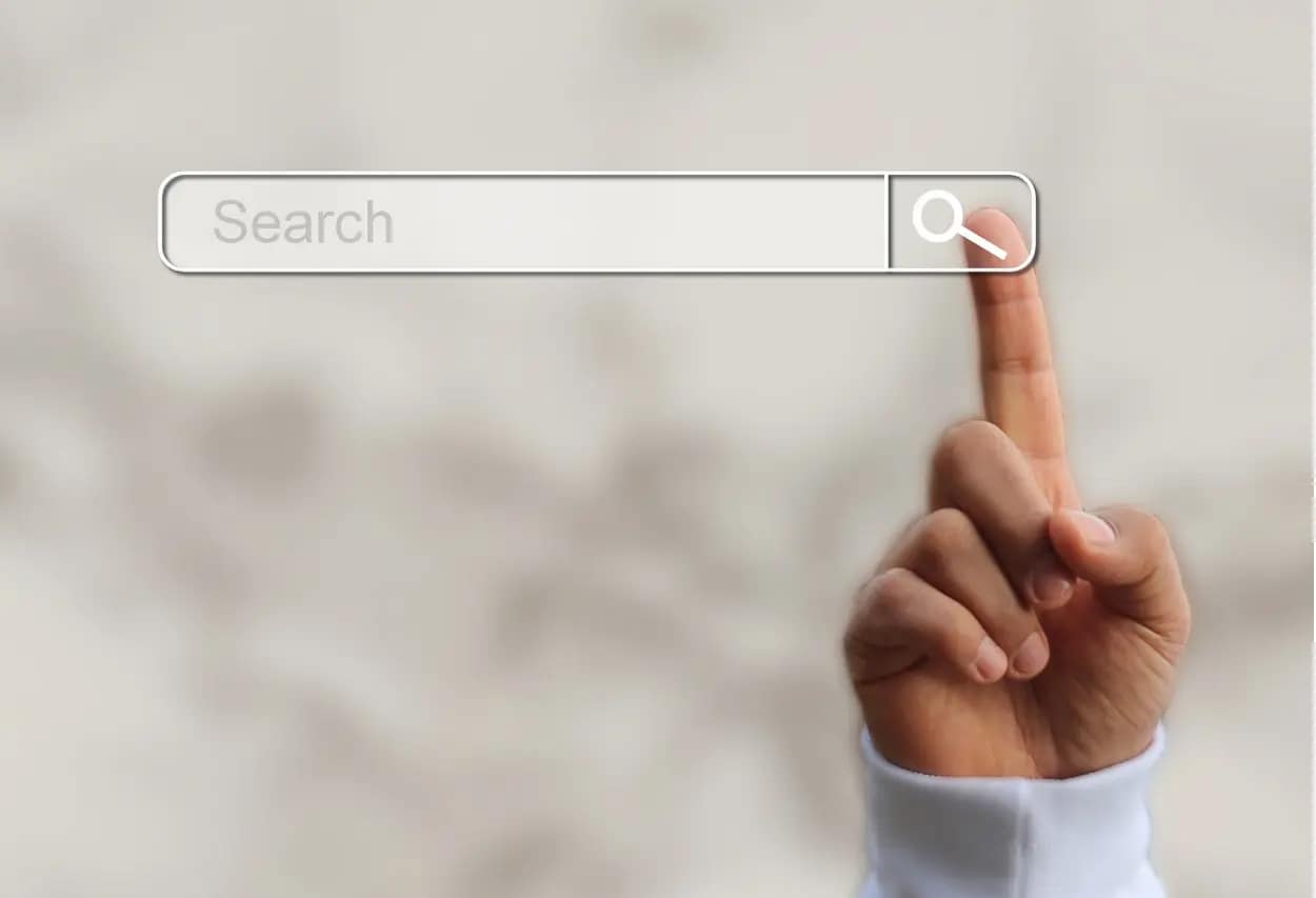 Finger pressing a virtual search button.