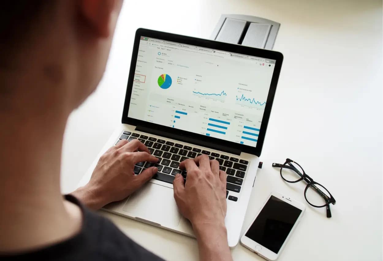 SEO professional analyzing audit reports on a laptop screen, with graphs and pie charts illustrating website performance metrics
