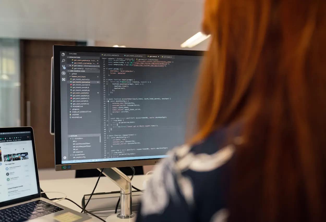 Developer conducting SEO audit using code editor on a computer monitor, with JavaScript visible, reflecting technical SEO analysis.