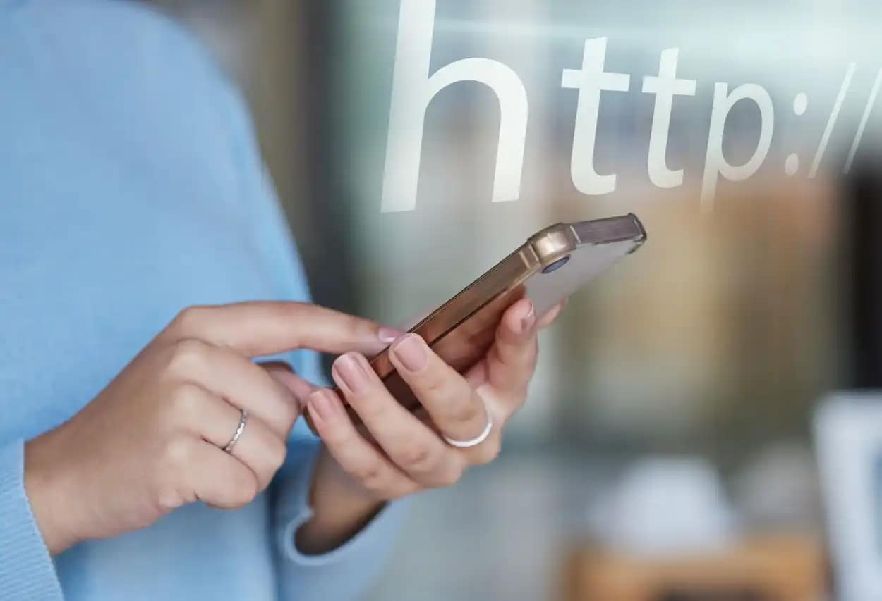 Close-up of a handheld device with a digital reflection, illustrating tracking the website online visibility and digital strategy success.