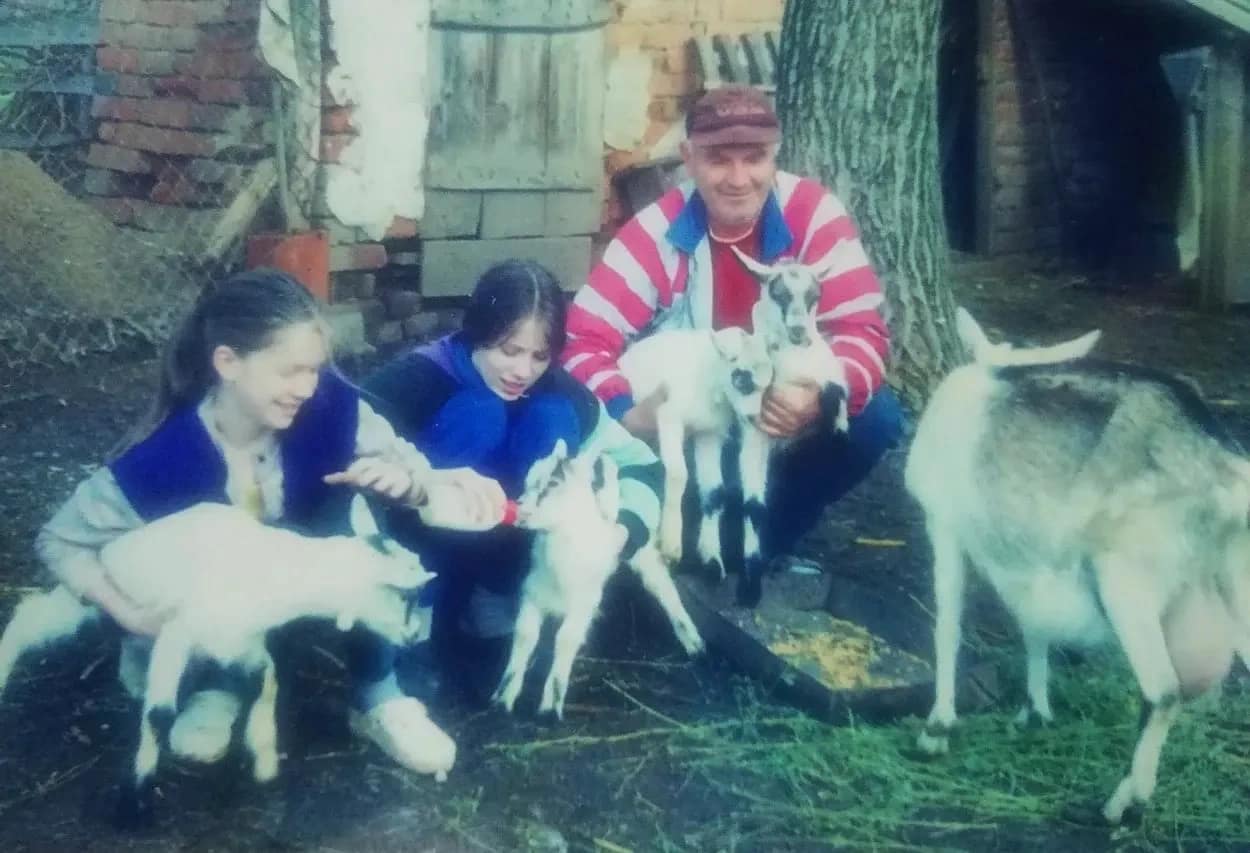 Family on the farm nursing baby goats