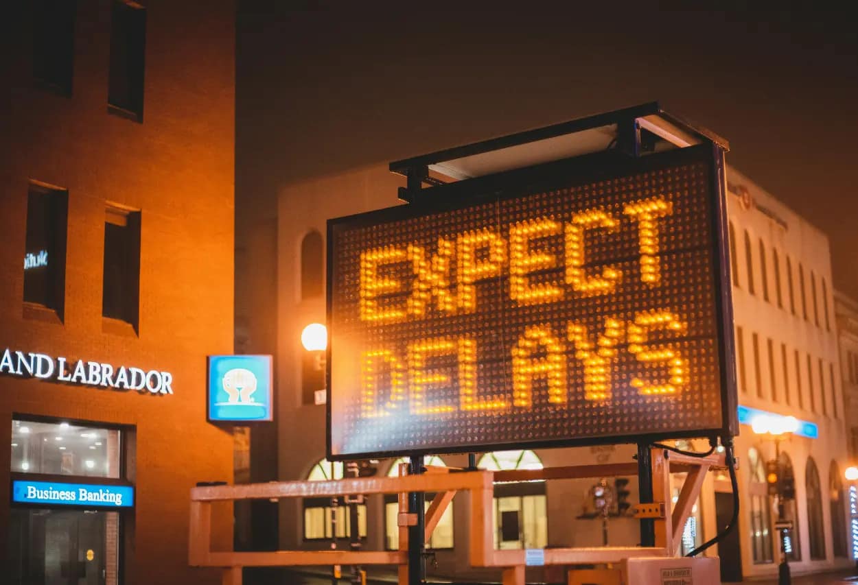 digital sign displaying "expect delays" on billboard