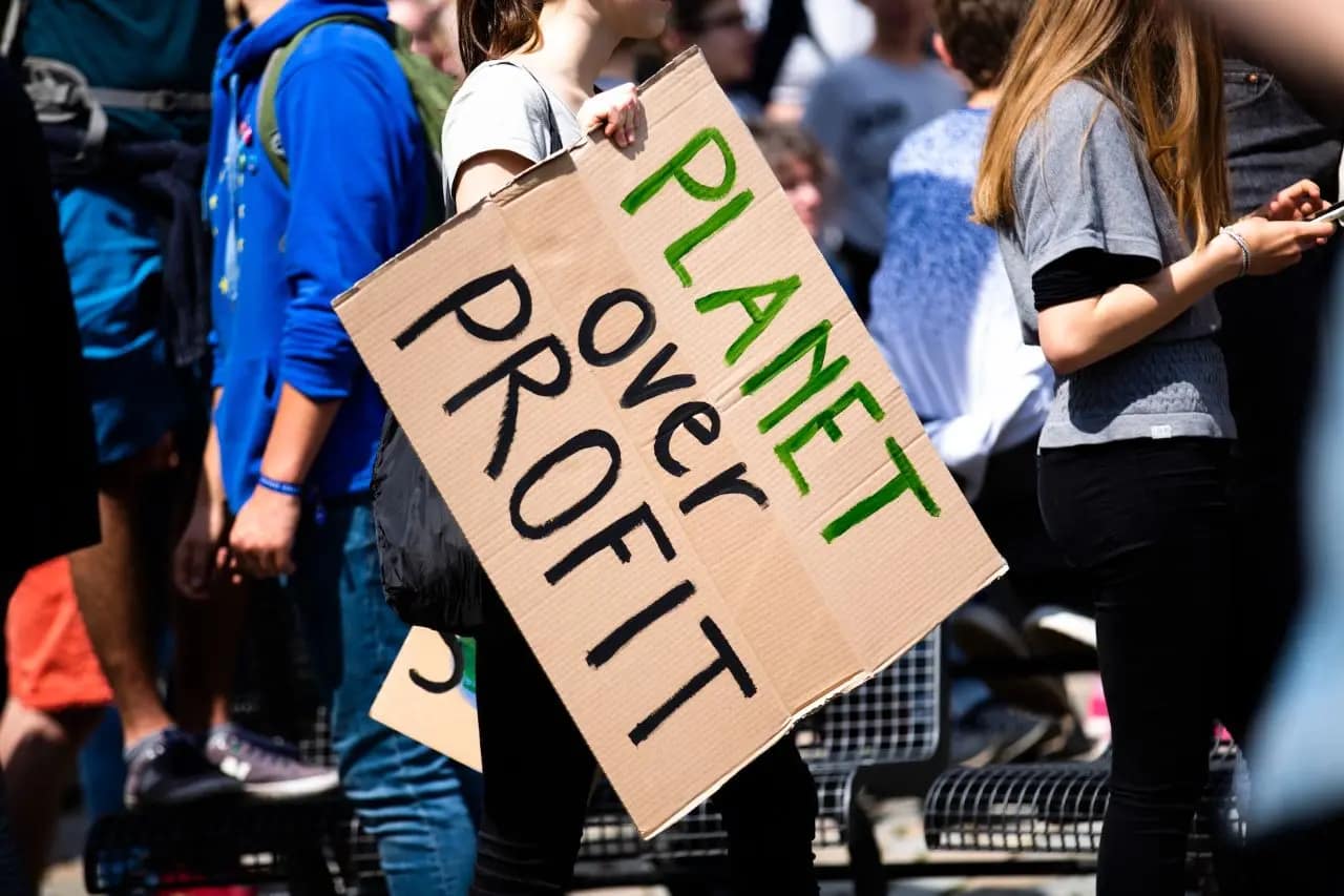 Cardboard sign that says "Planet over profit"