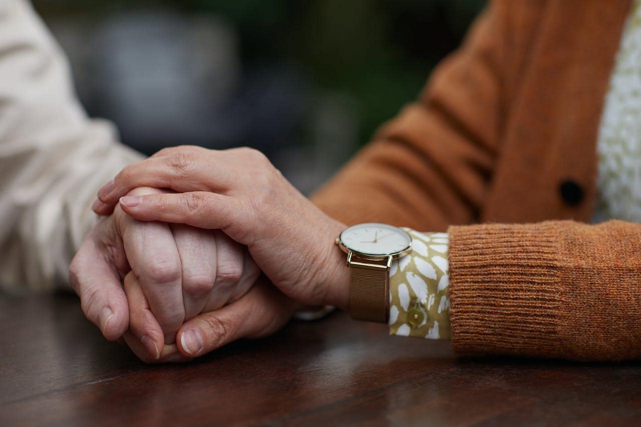 Two person holding hands as support to each other