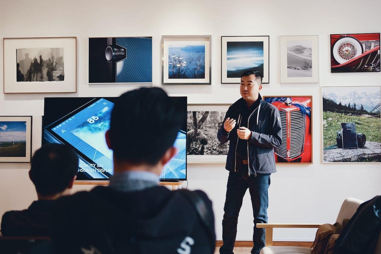 Asian man with a microphone holding a seminar on digital promotion of art