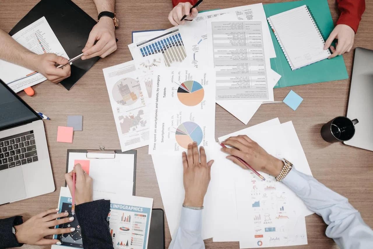 Content optimization team analyzing data charts and reports for strategic digital marketing planning.