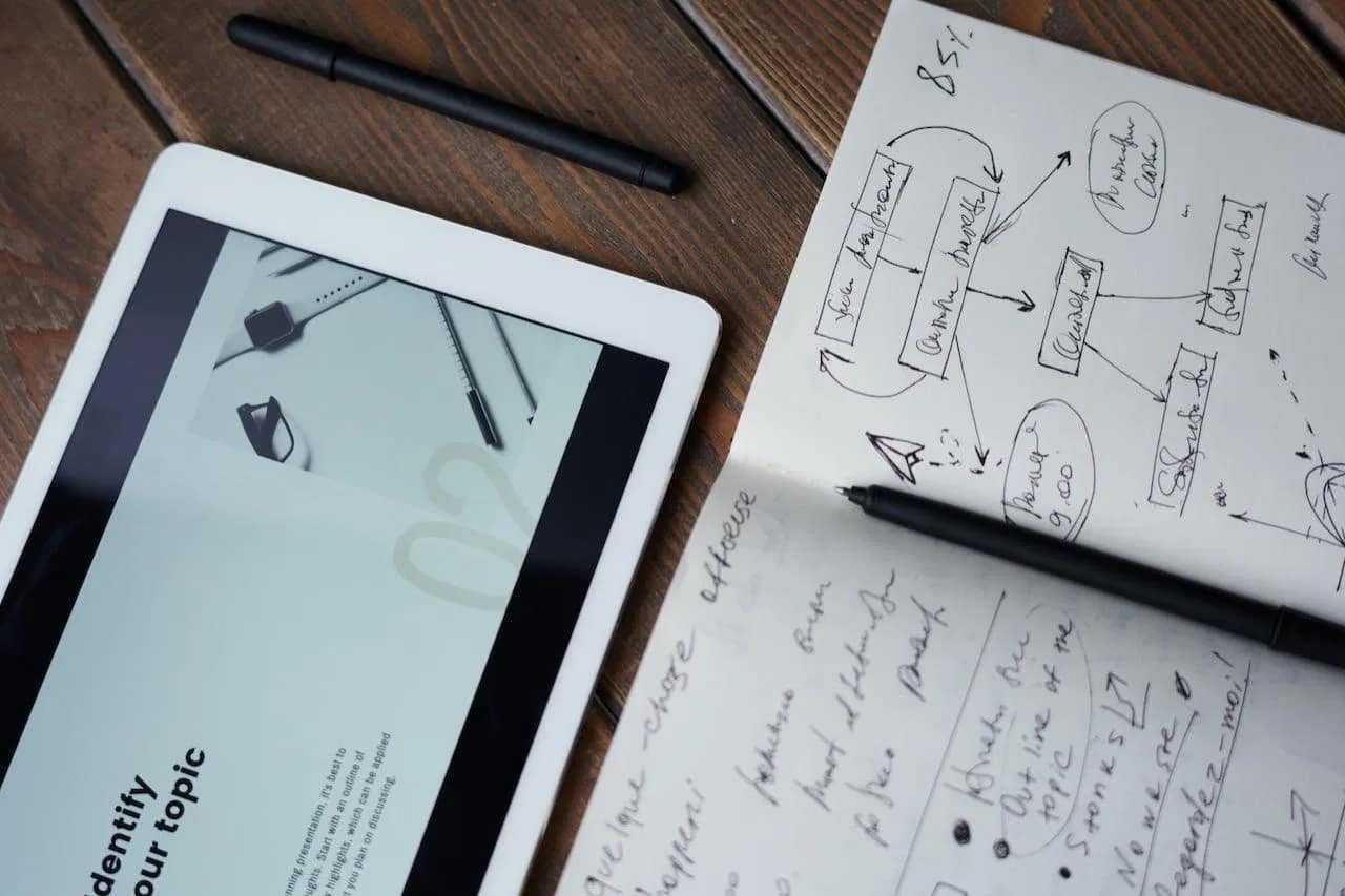 Content optimization specialist reviewing web design elements on a tablet beside handwritten SEO notes.