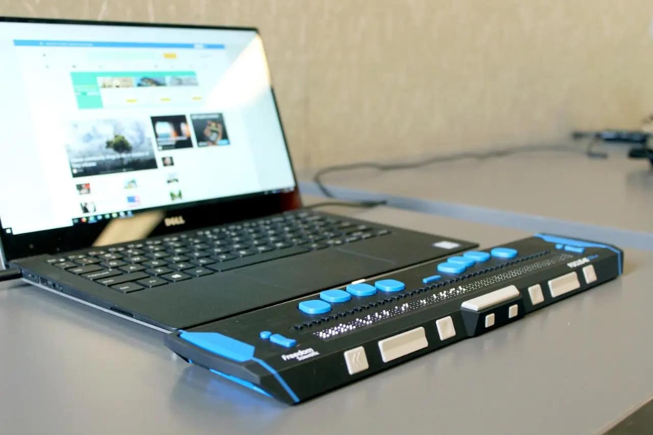 Assistive braille device connected to a laptop demonstrating accessibility features for the visually impaired