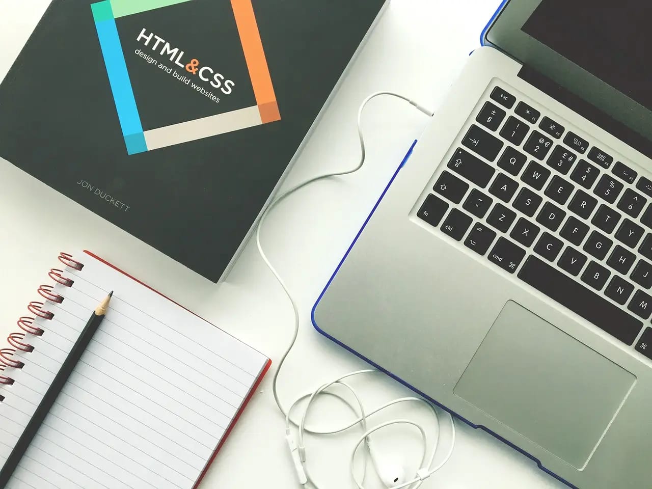 Laptop and a book about HTML, CSS and Technical SEO Fundamentals
